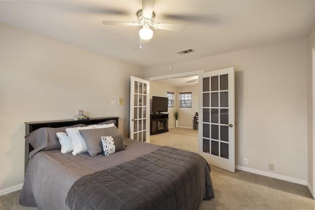 carpeted bedroom with ceiling fan and french doors