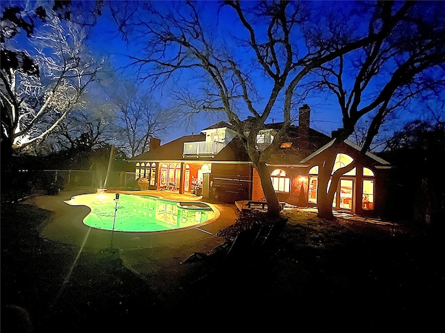 pool at twilight featuring a patio