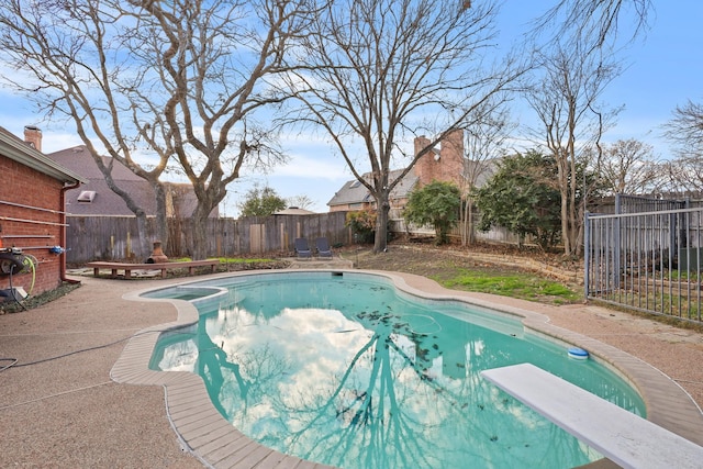 view of swimming pool with a patio area and a diving board