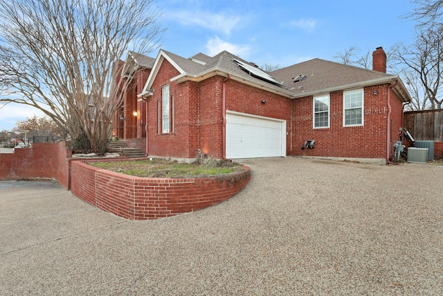 view of home's exterior featuring a garage, cooling unit, and solar panels