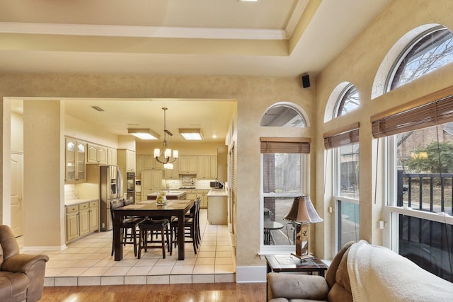 dining space featuring crown molding, a chandelier, and light wood-type flooring