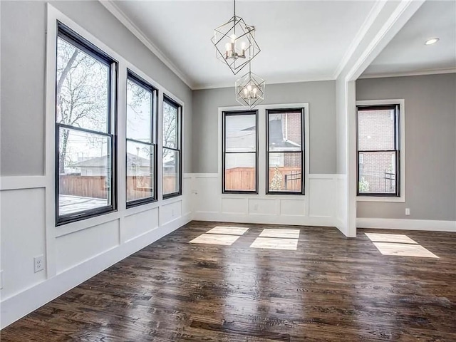 unfurnished dining area featuring dark hardwood / wood-style floors, a chandelier, and ornamental molding