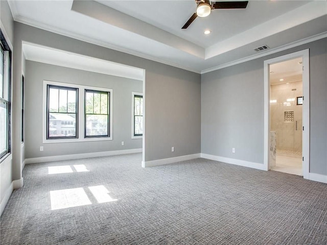 carpeted empty room with ceiling fan, a tray ceiling, and crown molding