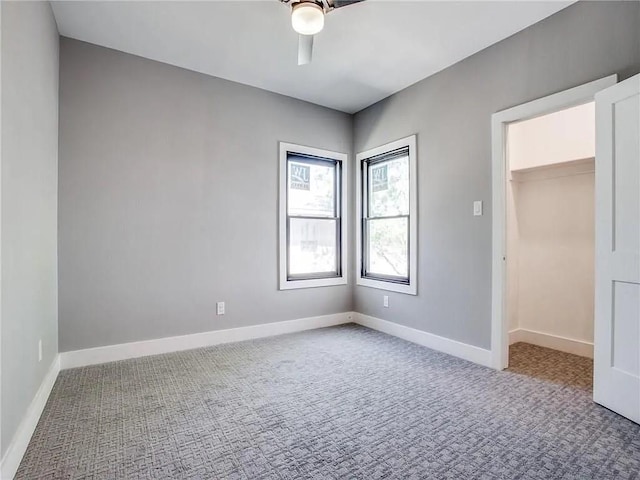 carpeted spare room featuring ceiling fan