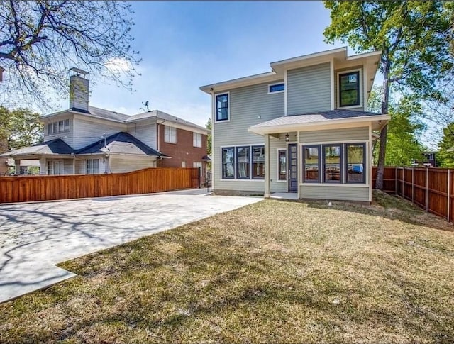 rear view of house featuring a yard