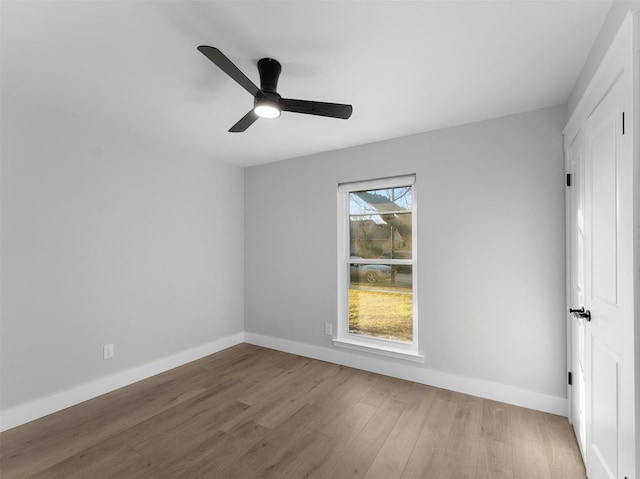 spare room featuring ceiling fan, a wealth of natural light, and hardwood / wood-style flooring