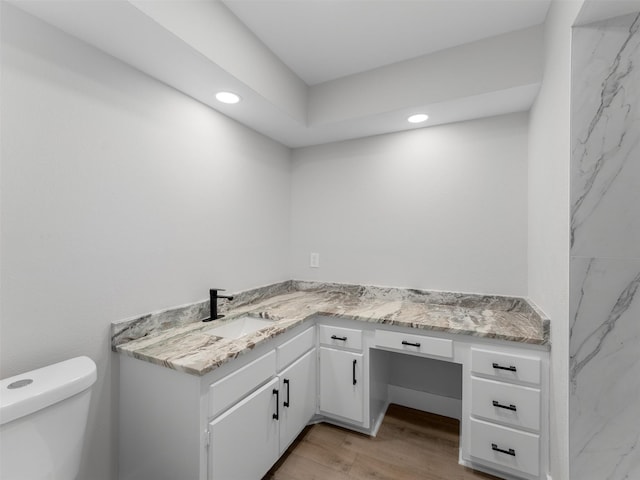 bathroom featuring toilet, wood-type flooring, and vanity