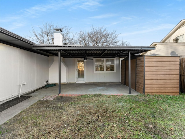 back of house featuring a patio area, a carport, and a yard