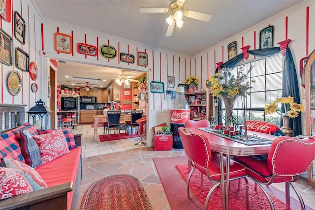 dining area with ceiling fan, ornamental molding, and a textured ceiling