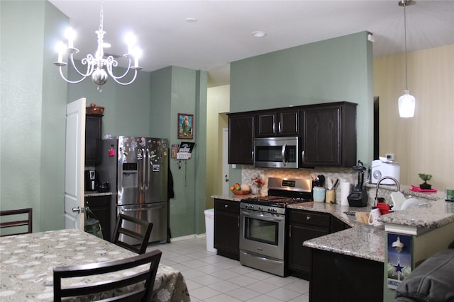 kitchen with light tile patterned flooring, tasteful backsplash, hanging light fixtures, kitchen peninsula, and stainless steel appliances