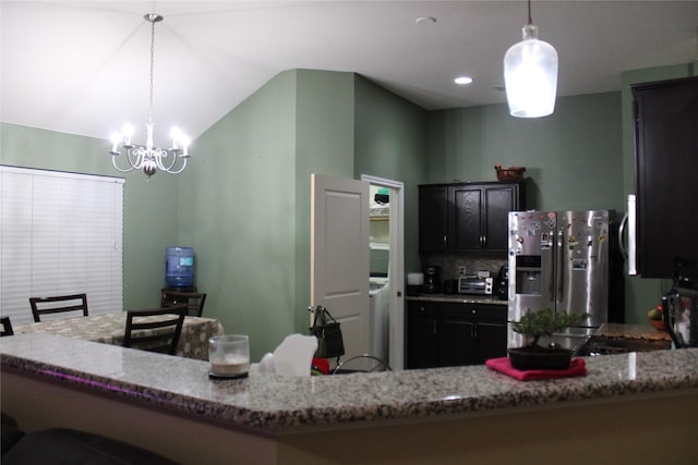 kitchen featuring hanging light fixtures, stainless steel refrigerator with ice dispenser, and light stone countertops