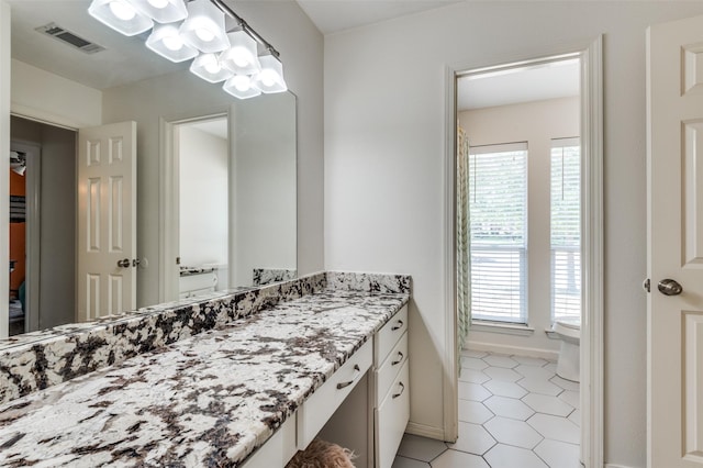 bathroom featuring toilet, vanity, and tile patterned flooring