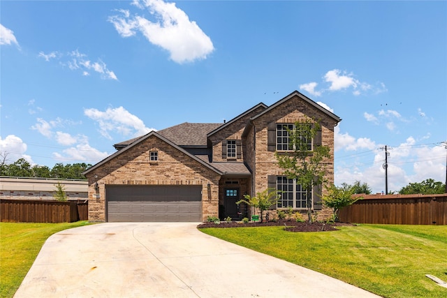 traditional home with driveway, fence, a front lawn, and brick siding