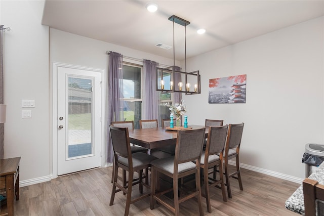 dining area featuring wood-type flooring and a chandelier