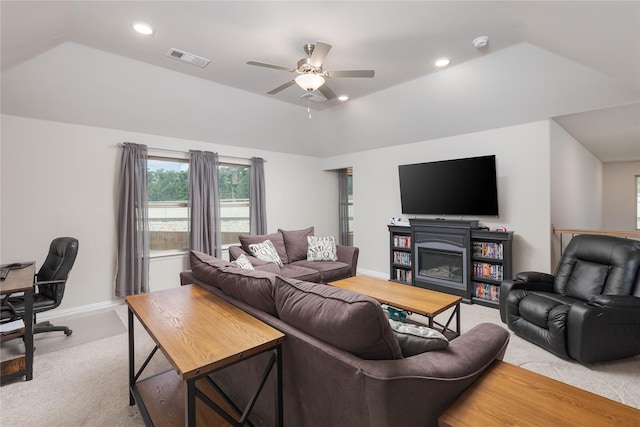 living room with ceiling fan, light colored carpet, and a tray ceiling