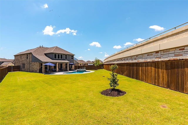 view of yard with a pool with connected hot tub and a fenced backyard