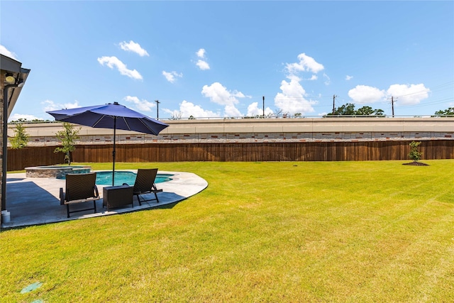 view of yard with a patio area and an in ground hot tub