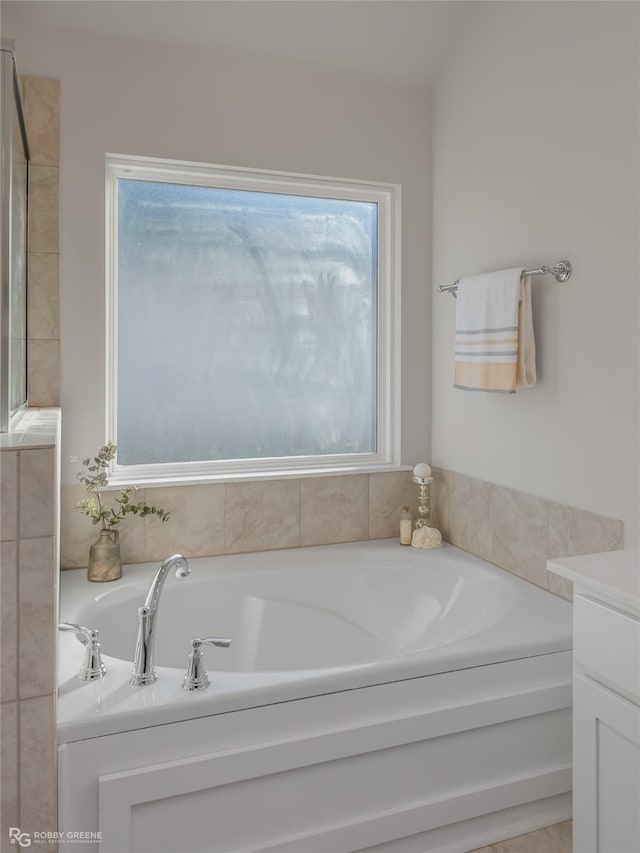 bathroom with a healthy amount of sunlight, vanity, and a bathing tub