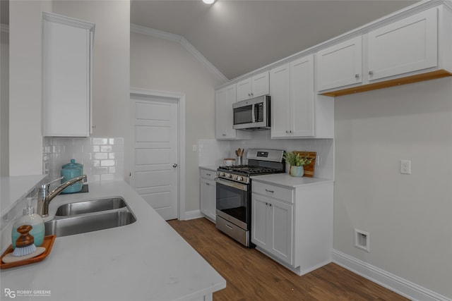 kitchen with lofted ceiling, white cabinets, sink, and stainless steel appliances