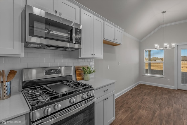 kitchen with vaulted ceiling, decorative backsplash, white cabinetry, appliances with stainless steel finishes, and ornamental molding