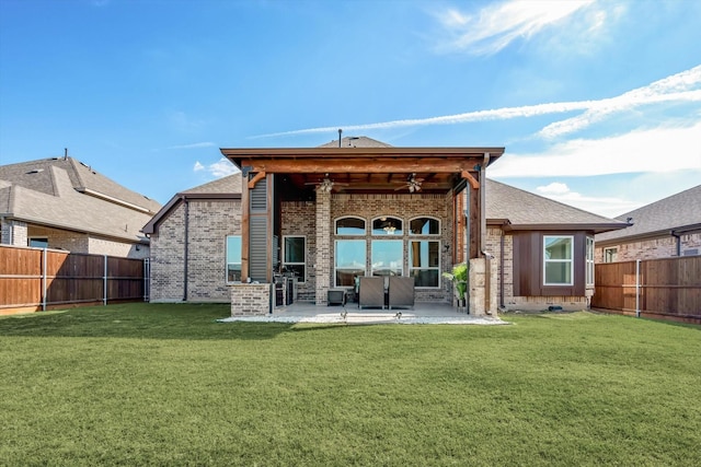 rear view of house featuring a ceiling fan, brick siding, a lawn, and a fenced backyard