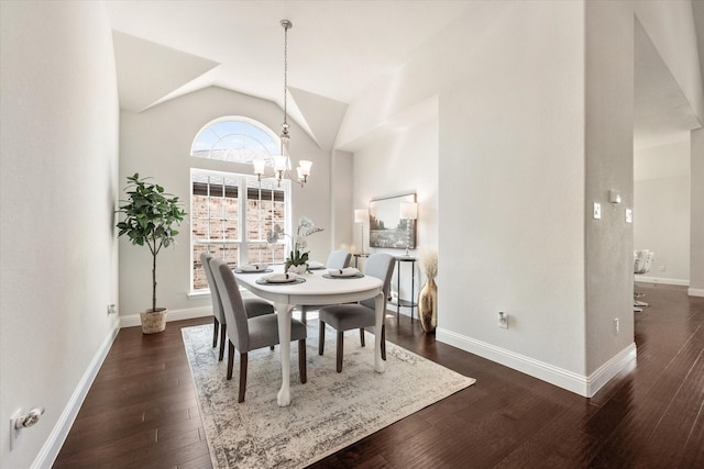 dining space with dark wood-type flooring, lofted ceiling, and a notable chandelier