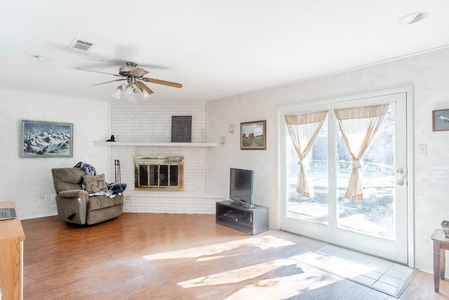 living room with ceiling fan, hardwood / wood-style floors, and a fireplace