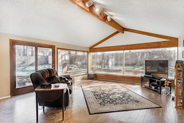 sunroom / solarium featuring vaulted ceiling with beams