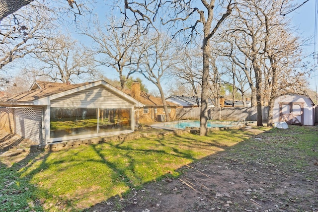 view of yard featuring a fenced in pool and a shed