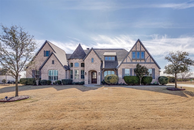 tudor-style house with a front lawn