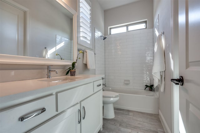 full bathroom featuring toilet, tiled shower / bath combo, and vanity