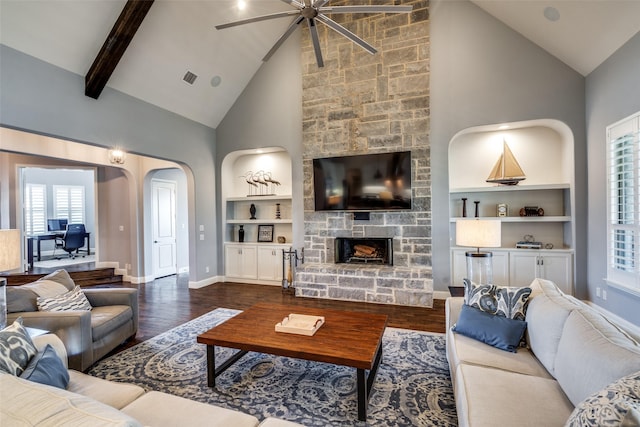 living room featuring ceiling fan, a fireplace, dark hardwood / wood-style floors, built in features, and high vaulted ceiling