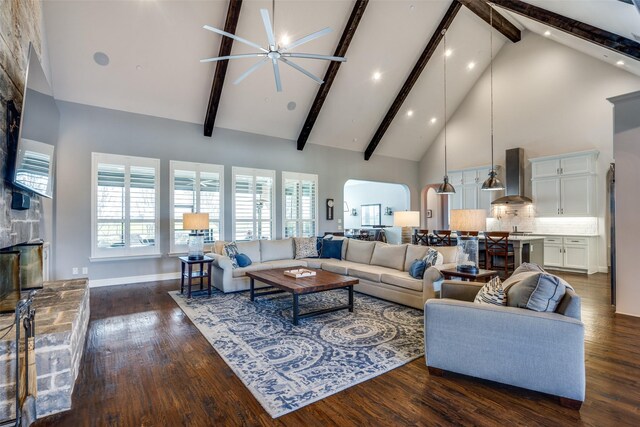 living room with high vaulted ceiling, ceiling fan, dark hardwood / wood-style floors, and beamed ceiling