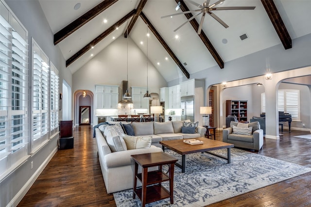 living room with beamed ceiling, ceiling fan, dark hardwood / wood-style flooring, and high vaulted ceiling