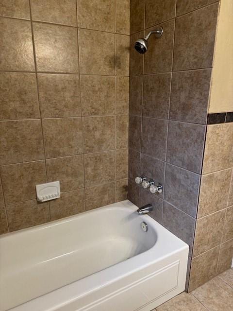 bathroom with tiled shower / bath combo and tile patterned flooring