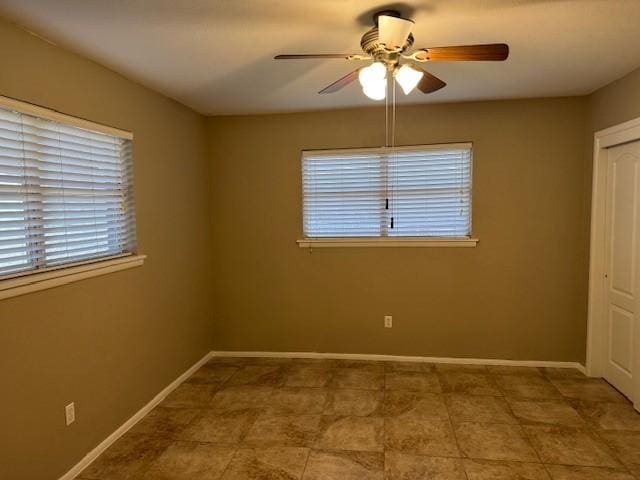 spare room with ceiling fan and a healthy amount of sunlight