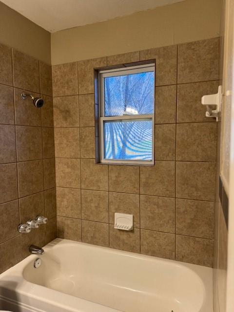 bathroom featuring tiled shower / bath