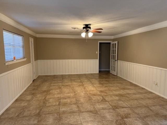 spare room featuring ceiling fan and ornamental molding