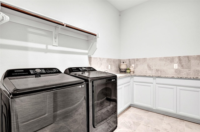 laundry area with washing machine and clothes dryer and cabinet space