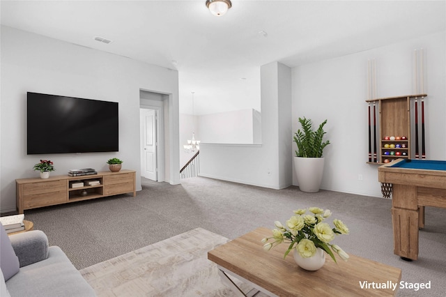 living room featuring carpet floors, a chandelier, and baseboards
