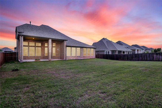 yard at dusk with a patio and a fenced backyard