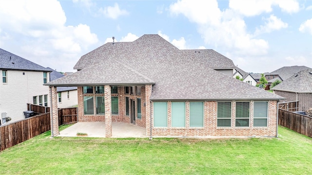 back of property with a patio area, a fenced backyard, a yard, and roof with shingles