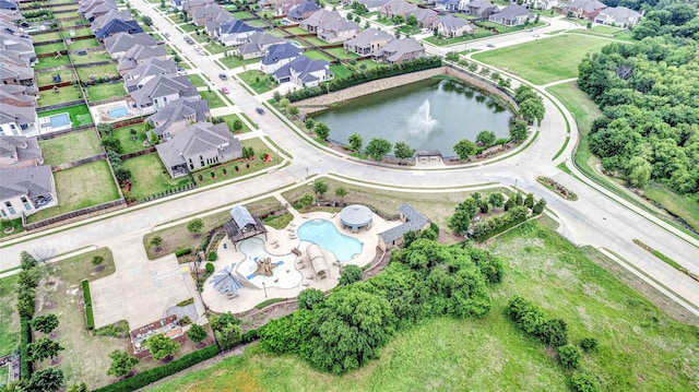 aerial view of property and surrounding area with a pool area, a nearby body of water, and nearby suburban area