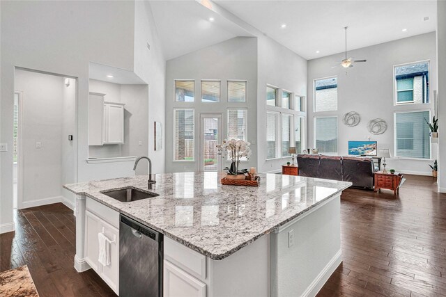 kitchen with a sink, open floor plan, an island with sink, dark wood-style floors, and stainless steel dishwasher