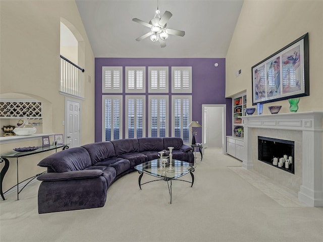 living room with built in shelves, light carpet, a towering ceiling, and a fireplace