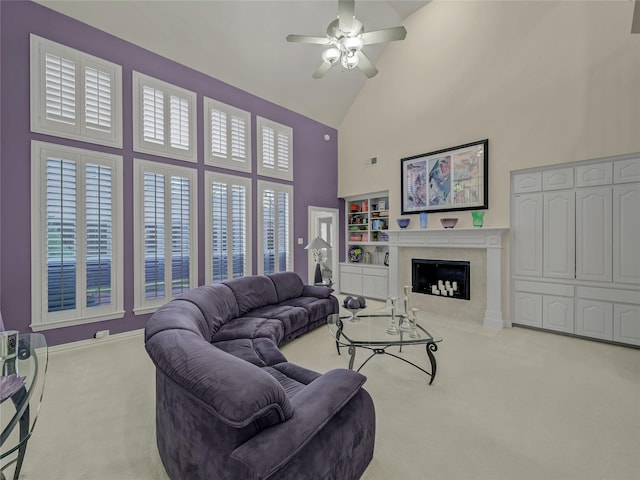 living room featuring light carpet, a premium fireplace, ceiling fan, and high vaulted ceiling