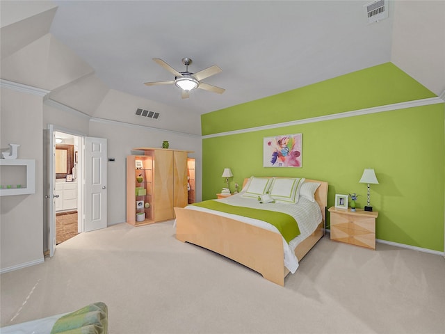 carpeted bedroom featuring ceiling fan, vaulted ceiling, crown molding, and ensuite bathroom