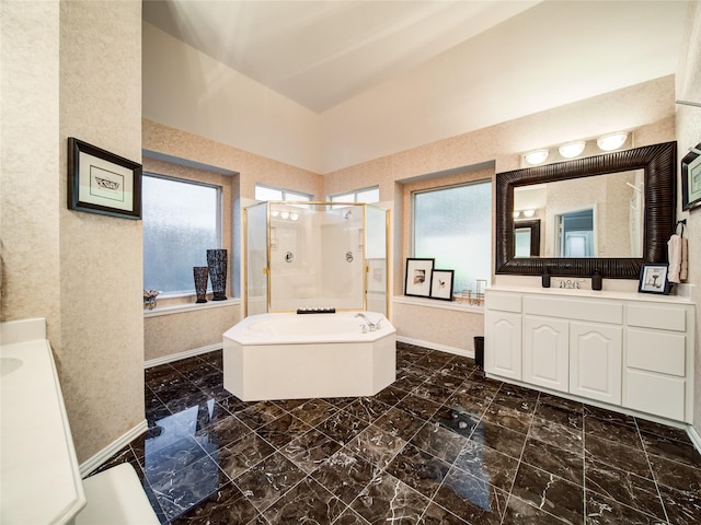 bathroom featuring vaulted ceiling, independent shower and bath, a healthy amount of sunlight, and vanity