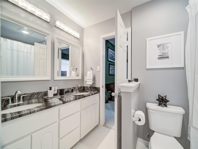 bathroom featuring toilet, tile patterned flooring, and vanity