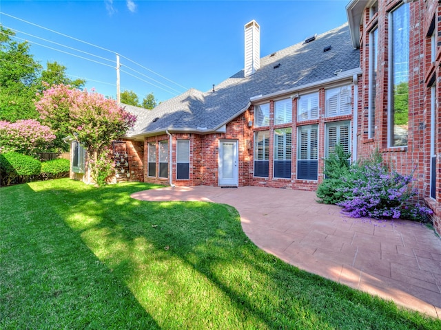 back of house featuring a patio area and a lawn